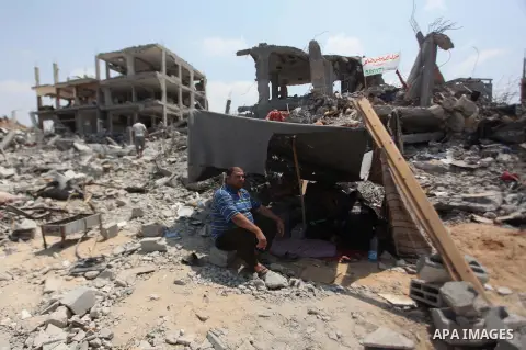 Palestinians set under a tent on the remains of their house which destroyed during fighting between Hamas militants and Israel in the Al-Shaaf neighbourhood, in Gaza City, on August 31, 2014. An indefinite ceasefire to e...
