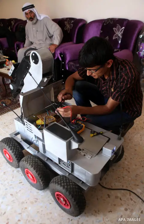 Khalil Awawdeh, a Palestinian inventor who works at his room in the West Bank city of Hebron on August 31, 2014. The 22-year-old man invents explosives detection device and he uses a cartoon to makes military tanks. Phot...