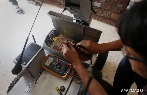Khalil Awawdeh, a Palestinian inventor who works at his room in the West Bank city of Hebron on August 31, 2014. The 22-year-old man invents explosives detection device and he uses a cartoon to makes military tanks. Phot...