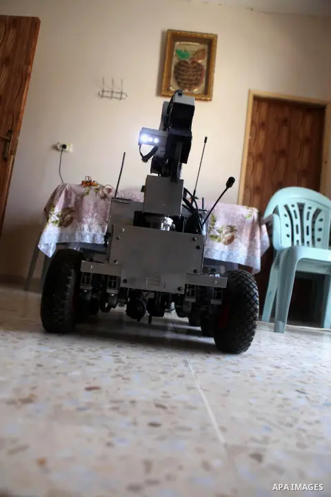 Khalil Awawdeh, a Palestinian inventor displays a military tank that he makes it by a cartoon in the West Bank city of Hebron on August 31, 2014. The 22-year-old man invents explosives detection device and he uses a cart...