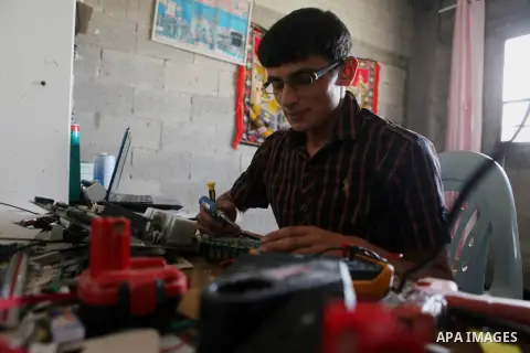 Khalil Awawdeh, a Palestinian inventor who works at his room in the West Bank city of Hebron on August 31, 2014. The 22-year-old man invents explosives detection device and he uses a cartoon to makes military tanks. Phot...