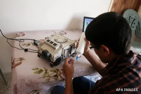 Khalil Awawdeh, a Palestinian inventor who works at his room in the West Bank city of Hebron on August 31, 2014. The 22-year-old man invents explosives detection device and he uses a cartoon to makes military tanks. Phot...