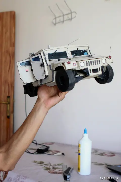 Khalil Awawdeh, a Palestinian inventor displays a military tank that he makes it by a cartoon in the West Bank city of Hebron on August 31, 2014. The 22-year-old man invents explosives detection device and he uses a cart...