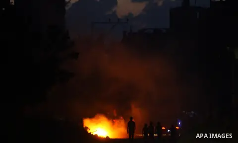 Palestinians gather around the fire inside the remains of their house that witnesses said were destroyed in an Israeli offensive, after a ceasefire was declared in the Shejaia neighbourhood, east of Gaza City. September...