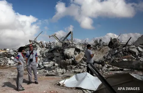 Palestinians inspect the rubble of a dairy factory demolished by Israeli bulldozers, at the al-Rama neighborhood near the West Bank city of Hebron on September 2, 2014. Israeli bulldozers demolished a dairy factory in He...