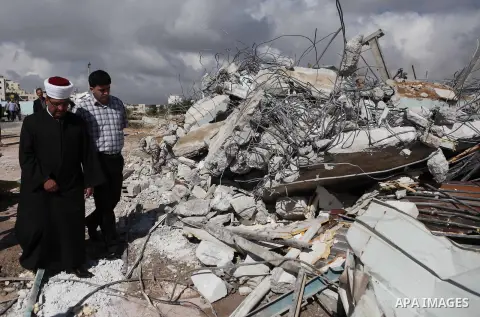 Palestinians inspect the rubble of a dairy factory demolished by Israeli bulldozers, at the al-Rama neighborhood near the West Bank city of Hebron on September 2, 2014. Israeli bulldozers demolished a dairy factory in He...