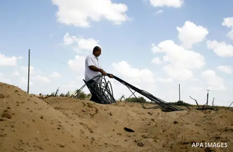 A Palestinian man inspects his farmland which destroyed during fighting between Hamas militants and Israel near the Israeli Gaza border fence in east of Khan Younis, southern Gaza Strip September 2, 2014. An open-ended c...