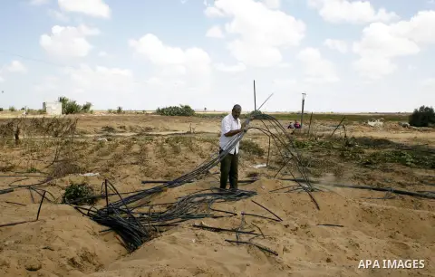 A Palestinian man inspects his farmland which destroyed during fighting between Hamas militants and Israel near the Israeli Gaza border fence in east of Khan Younis, southern Gaza Strip September 2, 2014. An open-ended c...