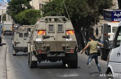 Palestinian youths throw at Israeli military patrols during a military operation at Ein Beit Alma' refugee camp near the West Bank city of Nablus, on Sep. 03, 2014. Photo by Nedal Eshtayah