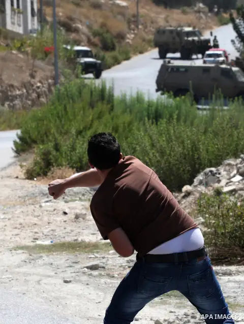 A Palestinian youth throws at Israeli military patrols during a military operation at Ein Beit Alma' refugee camp near the West Bank city of Nablus, on Sep. 03, 2014. Photo by Nedal Eshtayah