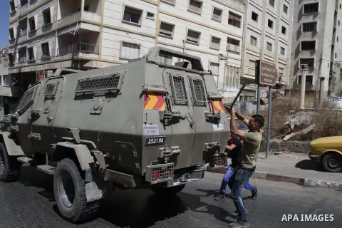 Palestinian youths throw at Israeli military patrols during a military operation at Ein Beit Alma' refugee camp near the West Bank city of Nablus, on Sep. 03, 2014. Photo by Nedal Eshtayah