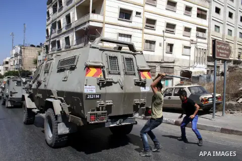 Palestinian youths throw at Israeli military patrols during a military operation at Ein Beit Alma' refugee camp near the West Bank city of Nablus, on Sep. 03, 2014. Photo by Nedal Eshtayah