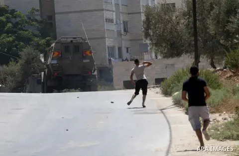Palestinian youths throw at Israeli military patrols during a military operation at Ein Beit Alma' refugee camp near the West Bank city of Nablus, on Sep. 03, 2014. Photo by Nedal Eshtayah