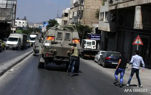 Palestinian youths throw at Israeli military patrols during a military operation at Ein Beit Alma' refugee camp near the West Bank city of Nablus, on Sep. 03, 2014. Photo by Nedal Eshtayah