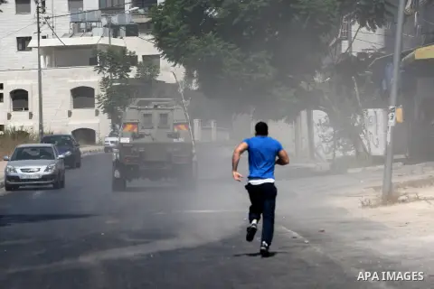 A Palestinian youth throws at Israeli military patrols during a military operation at Ein Beit Alma' refugee camp near the West Bank city of Nablus, on Sep. 03, 2014. Photo by Nedal Eshtayah