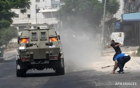 Palestinian youths throw at Israeli military patrols during a military operation at Ein Beit Alma' refugee camp near the West Bank city of Nablus, on Sep. 03, 2014. Photo by Nedal Eshtayah