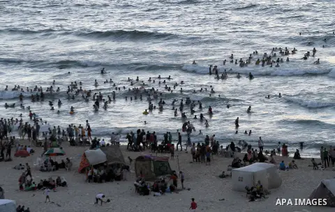 Palestinians enjoy swimming in the sea on Gaza's beach on Sep. 05, 2014. Photo by Mohammed Asad