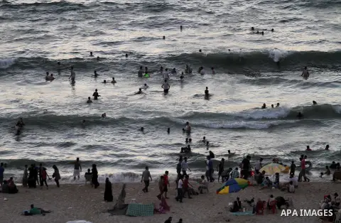 Palestinians enjoy swimming in the sea on Gaza's beach on Sep. 05, 2014. Photo by Mohammed Asad