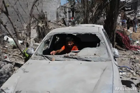A Palestinian boy sits inside the remains of a car that witnesses said was destroyed in an Israeli offensive, after a ceasefire was declared in the Shejaia neighbourhood, east of Gaza City. September 6, 2014. Calm return...