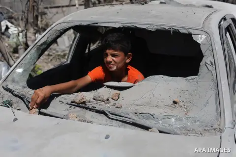 A Palestinian boy sits inside the remains of a car that witnesses said was destroyed in an Israeli offensive, after a ceasefire was declared in the Shejaia neighbourhood, east of Gaza City. September 6, 2014. Calm return...
