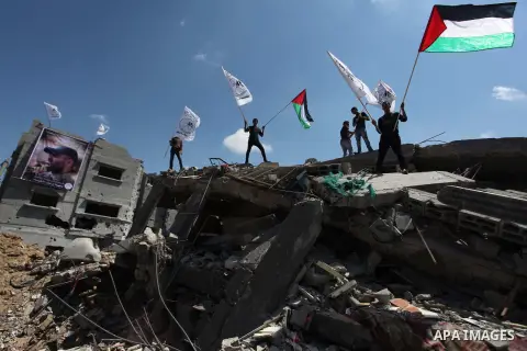 Palestinians hold national flags during a protest in the Shejaia neighbourhood, east of Gaza City. September 6, 2014. Calm returned to the coastal enclave in a August 26 ceasefire, and Gazans were gradually starting to r...