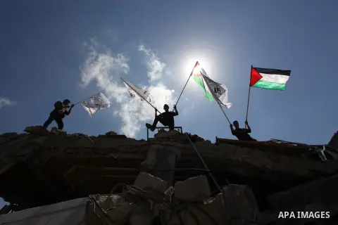 Palestinians hold national flags during a protest in the Shejaia neighbourhood, east of Gaza City. September 6, 2014. Calm returned to the coastal enclave in a August 26 ceasefire, and Gazans were gradually starting to r...