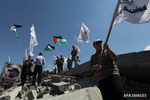 Palestinians hold national flags during a protest in the Shejaia neighbourhood, east of Gaza City. September 6, 2014. Calm returned to the coastal enclave in a August 26 ceasefire, and Gazans were gradually starting to r...