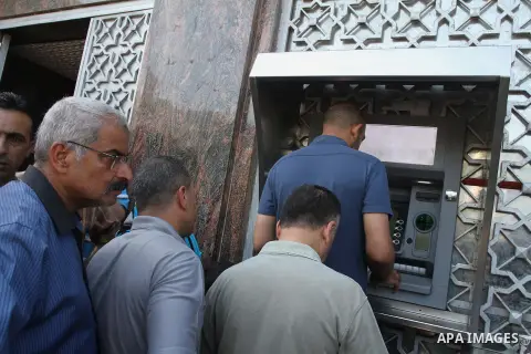 Palestinian employees paid by the Palestinian Authority wait to receive their salaries from an ATM, outside a Bank in Gaza City Sep. 07, 2014. Many issues involving the Strip, such as the fate of former employees of the...