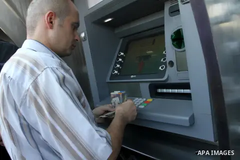 Palestinian employees paid by the Palestinian Authority wait to receive their salaries from an ATM, outside a Bank in Gaza City Sep. 07, 2014. Many issues involving the Strip, such as the fate of former employees of the...
