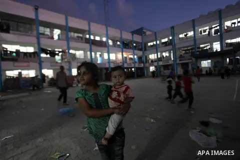 Palestinians watch children play a UN school in Beit Hanoun in northern Gaza strip on Sep. 07, 2014. Calm returned to the coastal enclave in a August 26 ceasefire, and Gazans were gradually starting to rebuild their live...