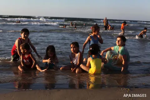 Palestinians enjoy swimming in the sea on Gaza's beach on Sep. 07, 2014. Photo by Ashraf Amra