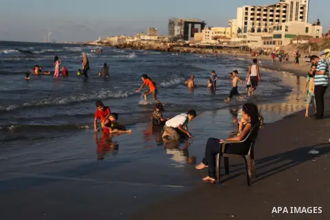 Palestinians enjoy swimming in the sea on Gaza's beach on Sep. 07, 2014. Photo by Ashraf Amra