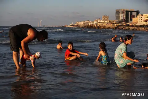 Palestinians enjoy swimming in the sea on Gaza's beach on Sep. 07, 2014. Photo by Ashraf Amra