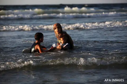 Palestinians enjoy swimming in the sea on Gaza's beach on Sep. 07, 2014. Photo by Ashraf Amra