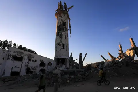Palestinian children walk in front of a mosque that destroyed by fighting between Hamas Militants and Israel during a conflict that saw over 2,100 Palestinians killed hundreds of thousands displaced by the fighting in Sh...