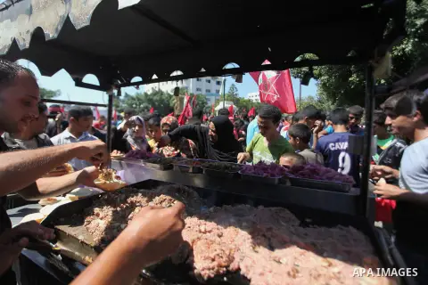 A Palestinian man sells meat sandwiches during a military show for the Democratic Front for the Liberation of Palestine (DFLP) in Gaza City September 11, 2014. An open-ended ceasefire between Israel and Hamas-led Gaza mi...