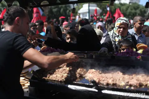 A Palestinian man sells meat sandwiches during a military show for the Democratic Front for the Liberation of Palestine (DFLP) in Gaza City September 11, 2014. An open-ended ceasefire between Israel and Hamas-led Gaza mi...