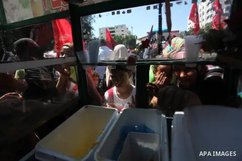 A Palestinian man sells icc cream during a military show for the Democratic Front for the Liberation of Palestine (DFLP) in Gaza City September 11, 2014. An open-ended ceasefire between Israel and Hamas-led Gaza militant...