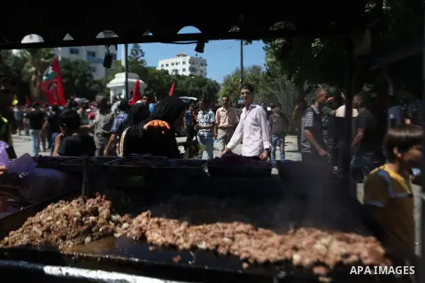 A Palestinian man sells meat sandwiches during a military show for the Democratic Front for the Liberation of Palestine (DFLP) in Gaza City September 11, 2014. An open-ended ceasefire between Israel and Hamas-led Gaza mi...