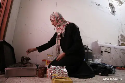 A Palestinian woman prepares tea in a destroyed house in Khan Yunis in the southern Gaza Strip on September 11, 2014. Israel's deputy foreign minister,Tzahi Hanegbi , warned that Hamas was likely to resume "violence" if...
