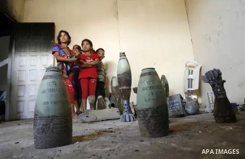 Palestinian children look at mortars and spent ammunition that, Suleiman Abu Jamaa, 35, collected around his destroyed home in Khan Yunis in the southern Gaza Strip on September 11, 2014. Israel's deputy foreign minister...