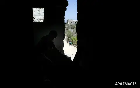 A Palestinian boy looks throw a hole in a destroyed house in Khan Yunis in the southern Gaza Strip on September 11, 2014. Israel's deputy foreign minister,Tzahi Hanegbi , warned that Hamas was likely to resume "violence"...