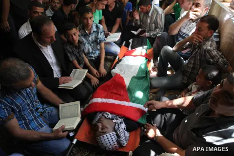 Relatives and friends gather around the body of Palestinian Raed al-Jabari, 35, during his funeral in the West Bank city of Hebron, September 12, 2014. Al-Jabari died on Tuesday in Israel's Soroka Medical Center after Pa...