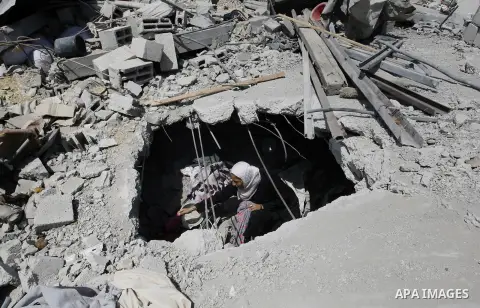 A Palestinian woman inspects her house, which witnesses said was destroyed by an Israeli air strike during a seven-week offensive, in the east of Khan Younis in the southern Gaza Strip September 13, 2014. An open-ended c...