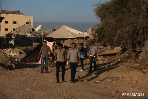 Palestinian students walk past houses that witnesses said were destroyed by the Israeli offensive, as they make their way to school on the first day of the new school year in the east of Gaza City September 14, 2014. An...