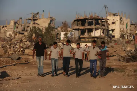 Palestinian students walk past houses that witnesses said were destroyed by the Israeli offensive, as they make their way to school on the first day of the new school year in the east of Gaza City September 14, 2014. An...