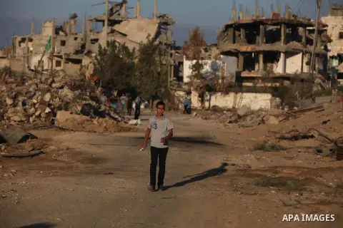 Palestinian students walk past houses that witnesses said were destroyed by the Israeli offensive, as they make their way to school on the first day of the new school year in the east of Gaza City September 14, 2014. An...