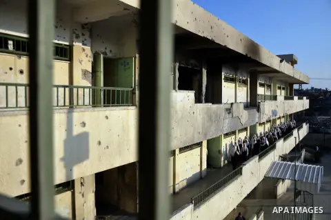 Palestinian students walk inside their school that witnesses said was shelled by Israel during its offensive, on the second day of the new school year in the east of Gaza City September 15, 2014. School year started in t...