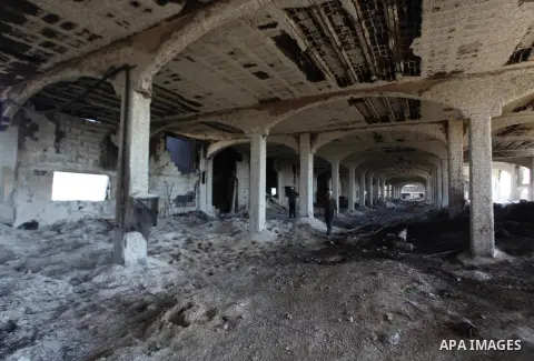 A Palestinian man inspects El-Awda factory that witnesses said was shelled by Israel during its offensive, in Gaza City September 16, 2014. An open-ended ceasefire between Israel and Hamas-led Gaza militants, mediated by...