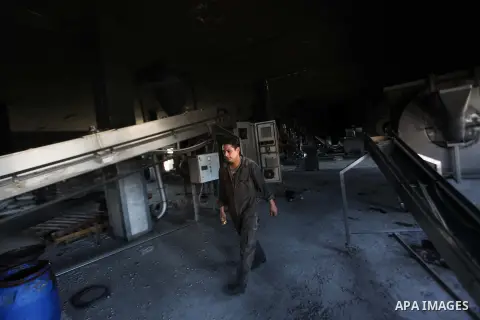 A Palestinian man inspects El-Awda factory that witnesses said was shelled by Israel during its offensive, in Gaza City September 16, 2014. An open-ended ceasefire between Israel and Hamas-led Gaza militants, mediated by...